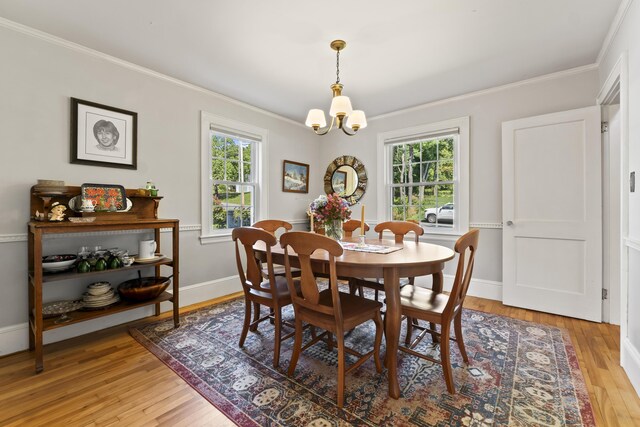 dining area featuring crown molding, a chandelier, and light hardwood / wood-style floors