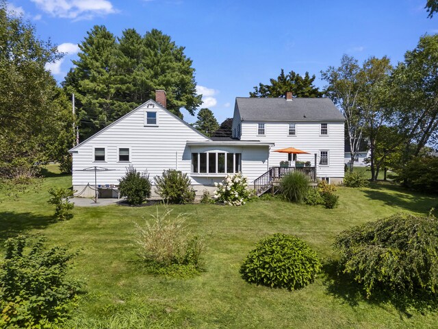 back of house featuring a yard and a wooden deck