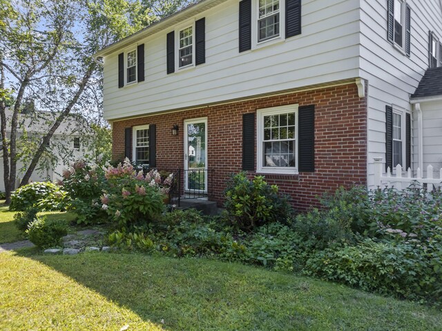 colonial house featuring a front lawn