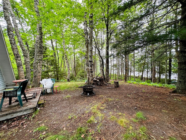 view of yard with a wooden deck and a fire pit