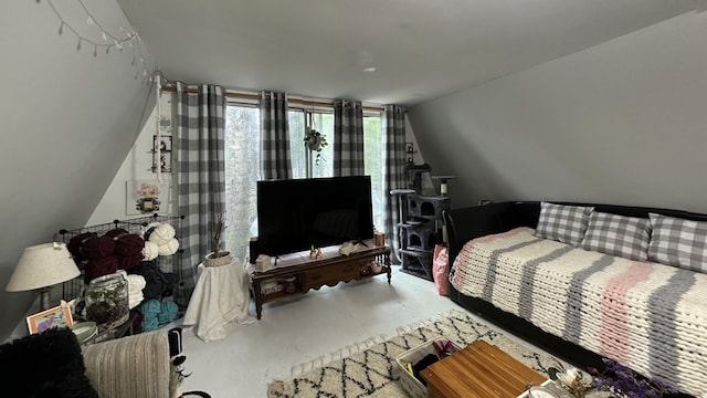 bedroom with vaulted ceiling and concrete floors