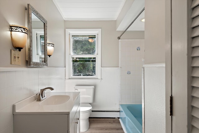 full bathroom with a baseboard heating unit, vanity, toilet, and tile walls