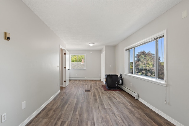 entrance foyer with a baseboard heating unit, a textured ceiling, and dark hardwood / wood-style floors