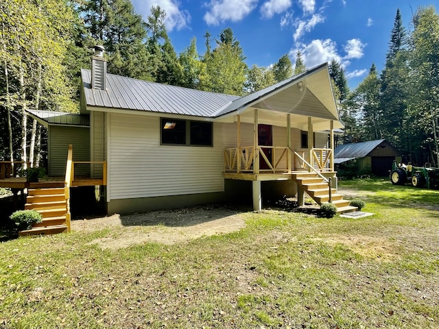 back of house with a lawn and covered porch