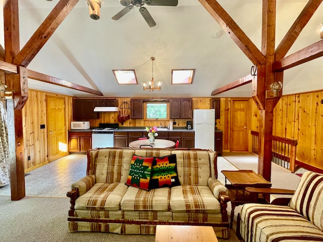 interior space with vaulted ceiling with beams, wooden walls, and ceiling fan with notable chandelier