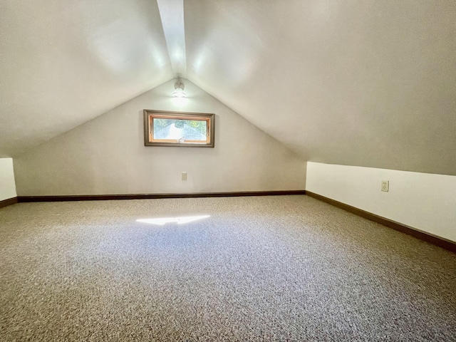 additional living space featuring vaulted ceiling and carpet floors