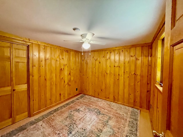 spare room featuring wooden walls and ceiling fan