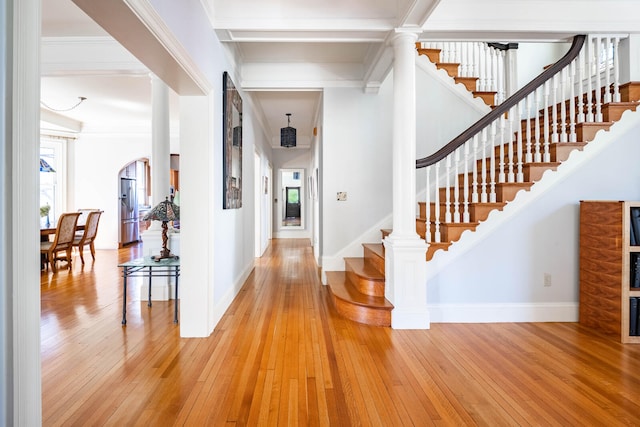 foyer entrance featuring crown molding, beamed ceiling, and hardwood / wood-style floors