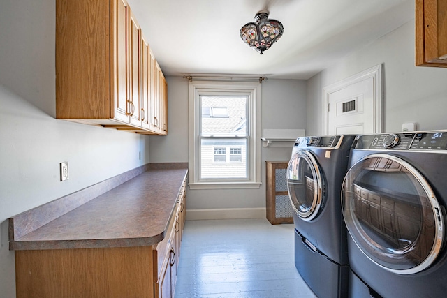 washroom with independent washer and dryer, light hardwood / wood-style floors, and cabinets