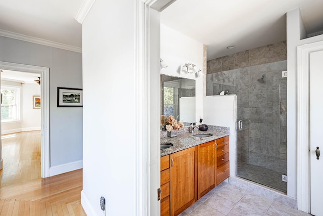 bathroom with vanity, crown molding, and a shower with door