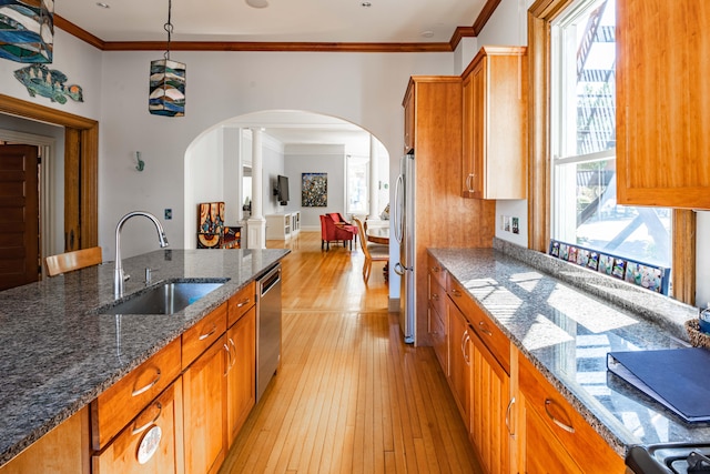 kitchen with a wealth of natural light, sink, light wood-type flooring, and appliances with stainless steel finishes