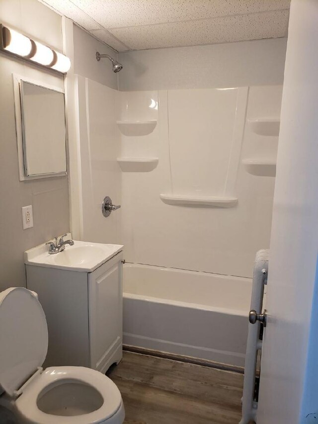 full bathroom featuring a drop ceiling, tub / shower combination, hardwood / wood-style floors, vanity, and toilet