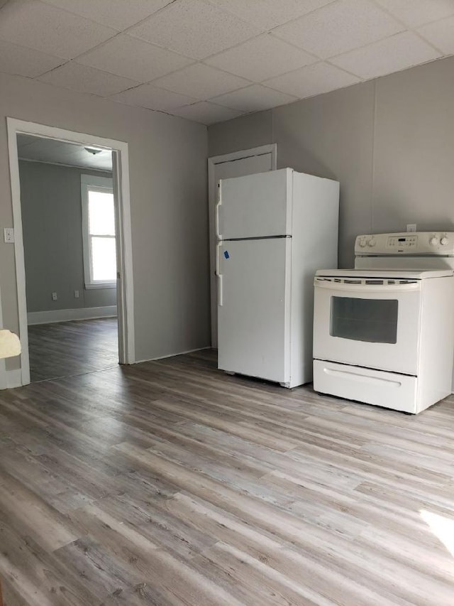 kitchen with hardwood / wood-style flooring, a paneled ceiling, and white appliances