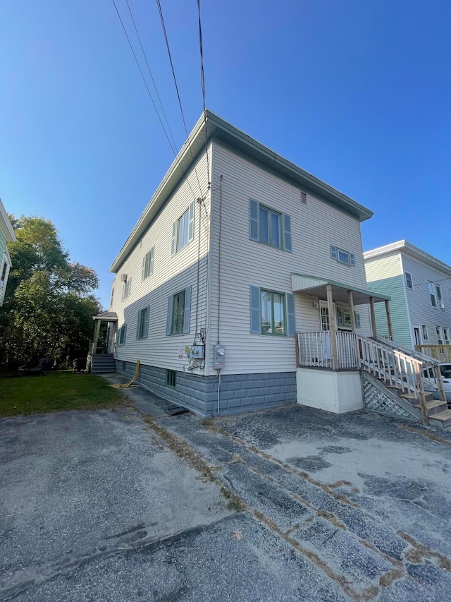 rear view of property featuring covered porch