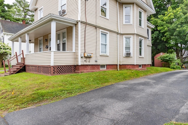 view of property exterior with a lawn and covered porch