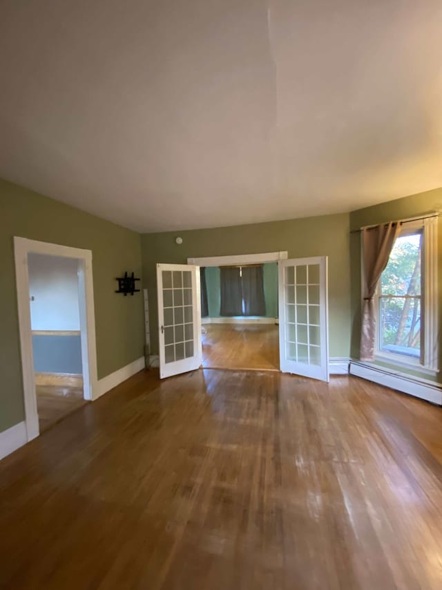 unfurnished room with french doors, baseboards, and wood finished floors