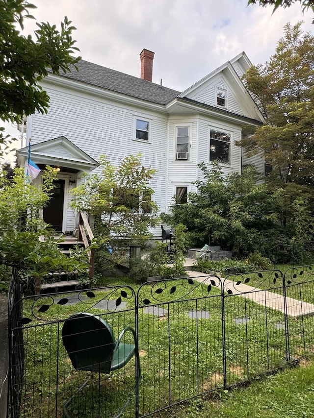 exterior space featuring a chimney, a front yard, fence, and a patio