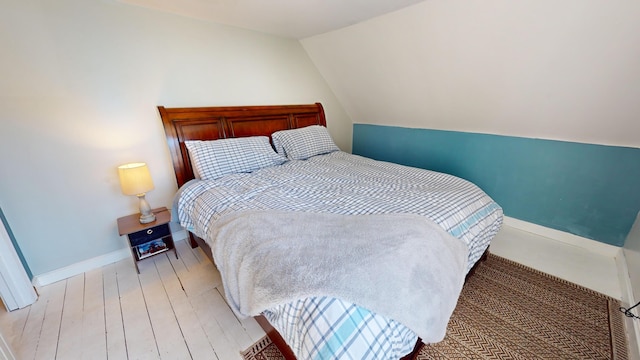 bedroom with light hardwood / wood-style flooring and vaulted ceiling