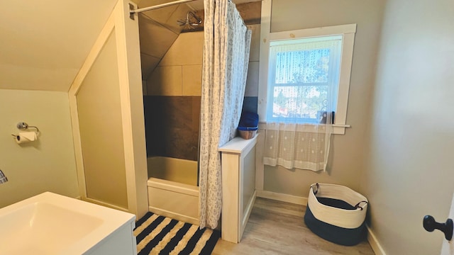 bathroom featuring wood-type flooring and shower / bathtub combination with curtain