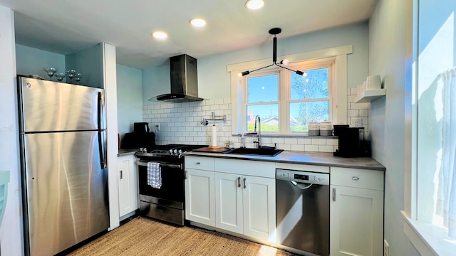 kitchen with backsplash, light wood-type flooring, stainless steel appliances, sink, and wall chimney range hood