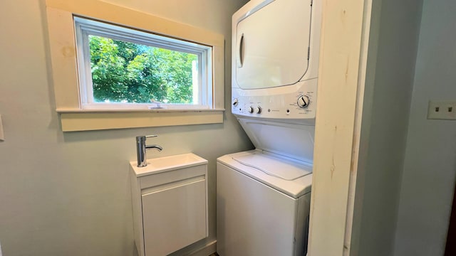 laundry area featuring cabinets, sink, and stacked washer and dryer