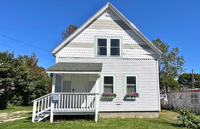 rear view of house with a porch and a yard