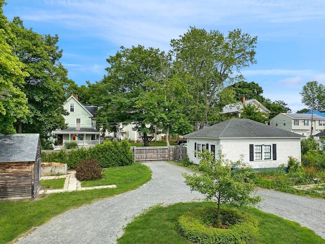 view of home's community with driveway and fence