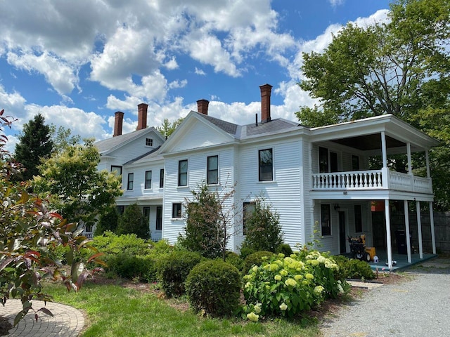 back of property with a patio area, a chimney, and a balcony