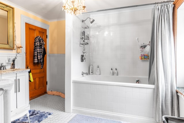 full bathroom featuring an inviting chandelier, ornamental molding, vanity, and tiled shower / bath combo