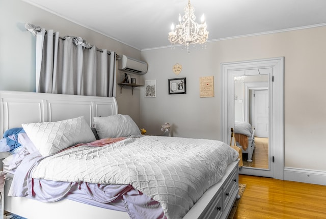 bedroom with light hardwood / wood-style flooring, ornamental molding, an AC wall unit, and a notable chandelier