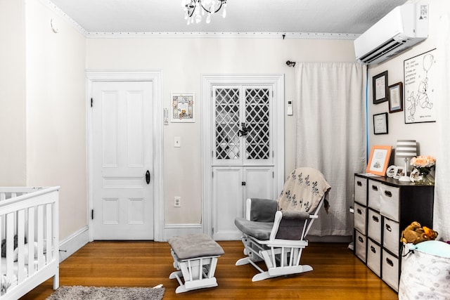 living area with a wall mounted AC, a notable chandelier, and hardwood / wood-style flooring