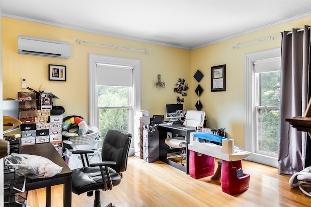 office with a wealth of natural light, ornamental molding, a wall unit AC, and wood-type flooring