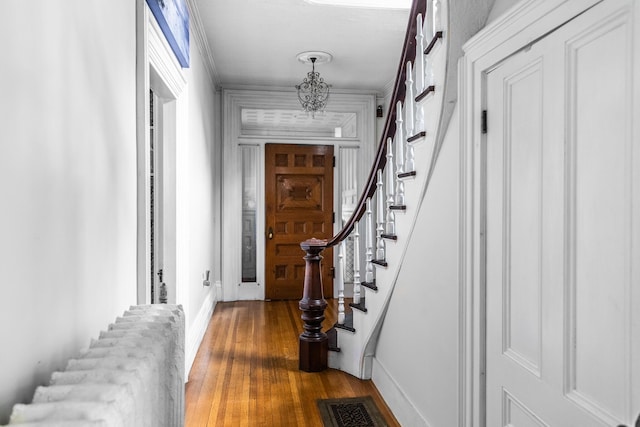 interior space featuring stairway, wood finished floors, baseboards, ornamental molding, and visible vents