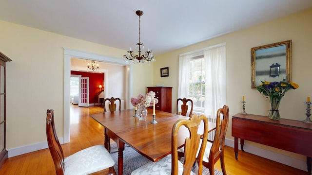 dining space with a chandelier and light hardwood / wood-style flooring