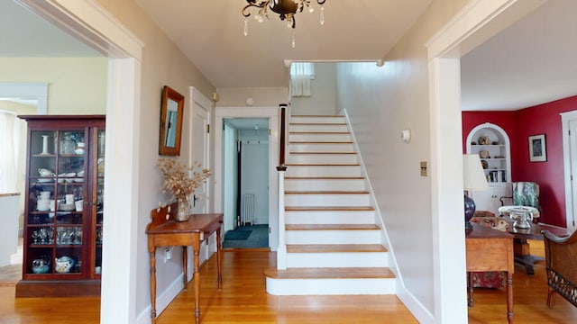 staircase featuring radiator heating unit and hardwood / wood-style flooring