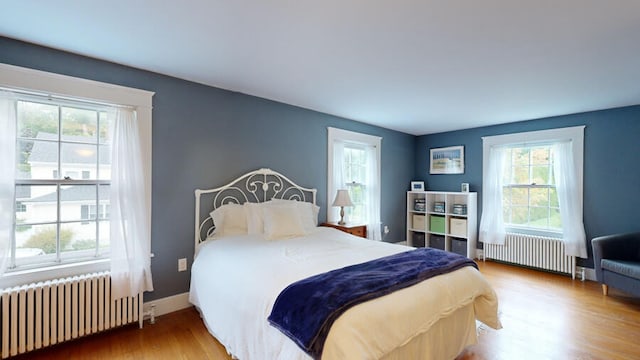 bedroom with radiator and hardwood / wood-style floors