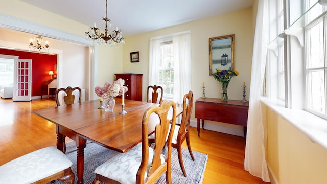 dining area with light wood-type flooring and a chandelier