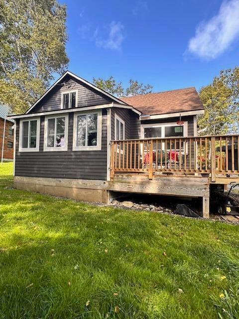 back of property featuring a lawn and a wooden deck