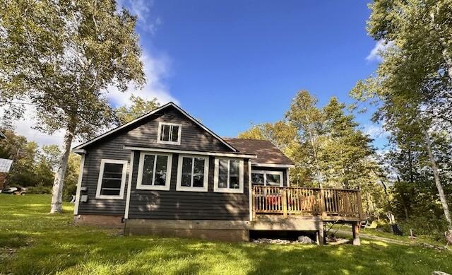 back of house with a wooden deck and a lawn