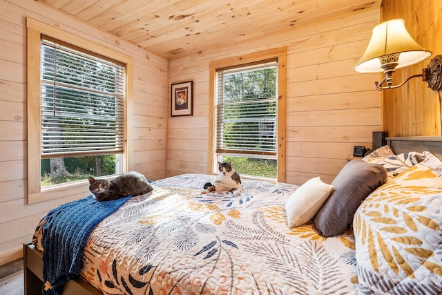 bedroom featuring multiple windows, wood ceiling, wood walls, and hardwood / wood-style flooring