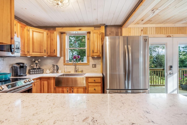 kitchen with appliances with stainless steel finishes, a healthy amount of sunlight, sink, and wooden ceiling