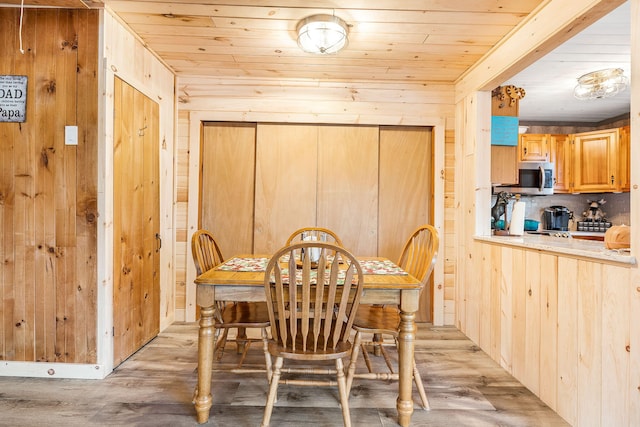 dining area featuring light hardwood / wood-style flooring and wood walls