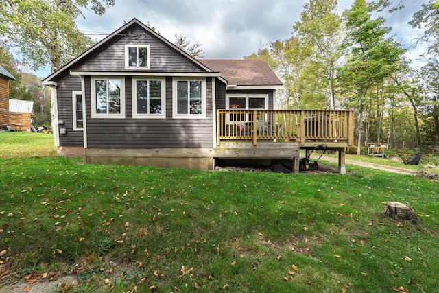 rear view of property featuring a lawn and a wooden deck