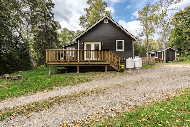 rear view of house featuring an outbuilding and a deck