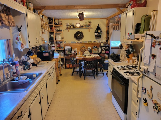 458 Lambert Rd, Brewer, ME 04412 - kitchen featuring a sink, gas range, freestanding refrigerator, light countertops, and a textured ceiling