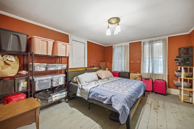 bedroom featuring light wood-type flooring and crown molding