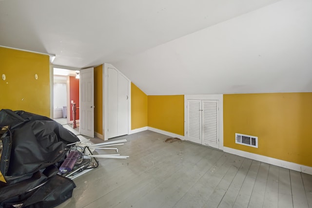 additional living space with lofted ceiling and hardwood / wood-style floors