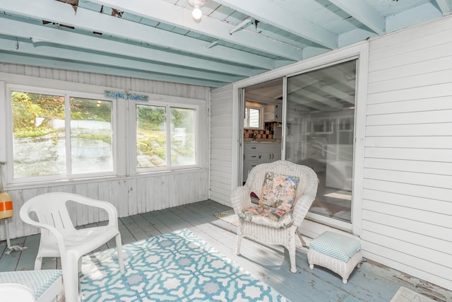 sunroom / solarium featuring beamed ceiling