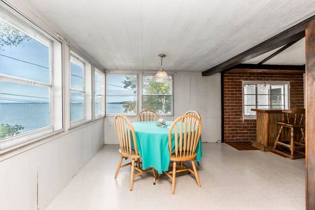 dining space featuring brick wall and a water view