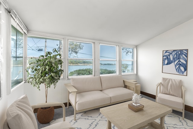 carpeted living room featuring lofted ceiling and a water view